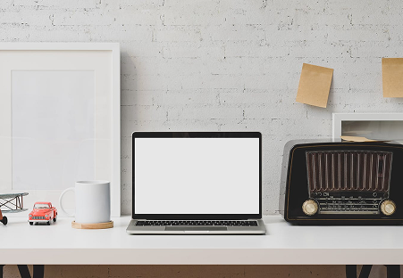 Minimalist work desk with laptop and radio