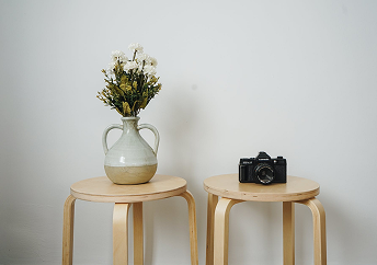 Two stools with a vase and camera